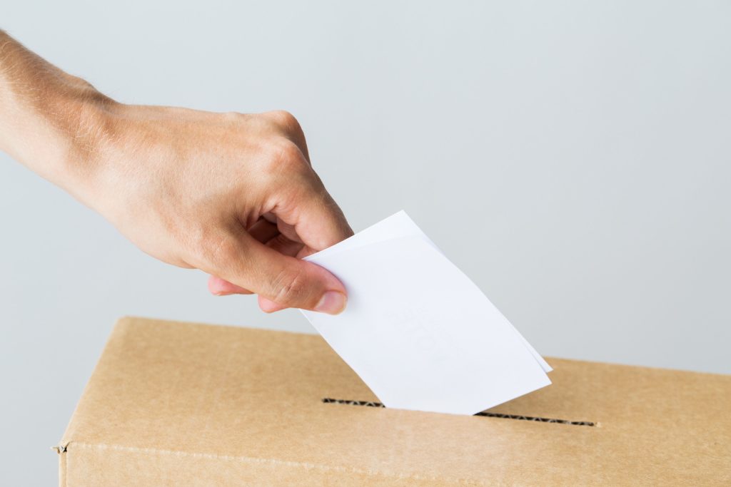 Man Putting His Vote Into Ballot Box On Election