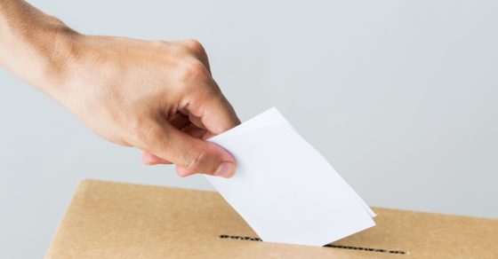 Man Putting His Vote Into Ballot Box On Election